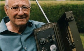 Portrait of Donald Lewes Hings holding a model of the walkie-talkie.