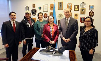 Six people stand together in an office at the United Nations International Maritime Organization