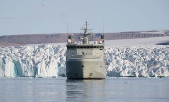 The HMCS Harry DeWolf floats in front of an ice field during Operation Nanook-Nunakput