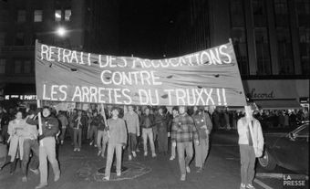 Protesters holding a banner advocating for those arrested during the Truxx police raid.