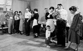 Deux infirmières de santé publique vaccinent des adultes dans un centre de vaccination contre la polio à Southey, en Saskatchewan, en 1960.