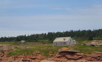 House by a red cliff.