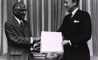 Har Gobind Khorana, Alfred Sloan Professor of Biology and Chemistry at the Massachusetts Institute of Technology (left), and Donald S. Fredrickson, director of the National Institutes of Health (NIH) (right), are shaking hands while holding the NIH lectur