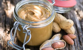 A jar of peanut butter and peanuts, date unknown.