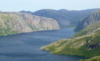 Lac entouré de montagnes rocheuses.