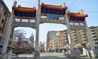 The gates to Chinatown above a road. Several buildings line the street.