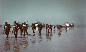 Des soldats d’infanterie canadiens débarquent de barges d’invasion à Normandie.