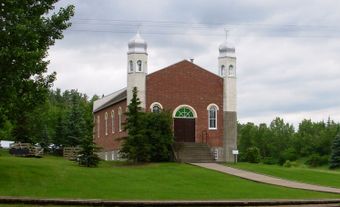 Une mosquée construite avec des briques rouges et deux minarets.