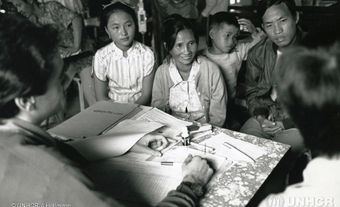 Des réfugiés laotiens reçoivent de l'information à propos de leur réinstallation, camp de Chiang Kham, Thaïlande, 1988