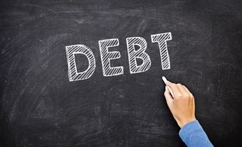 Chalk board showing the word “debt”