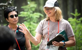 Suzanne Simard s’adresse à un groupe en forêt.