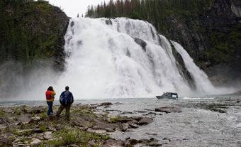 Waterfall, with two hikers in the foreground.